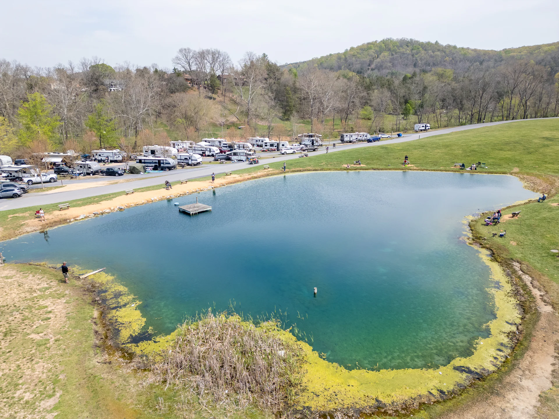 The campground pond with RV sites along the shore, seen from the air